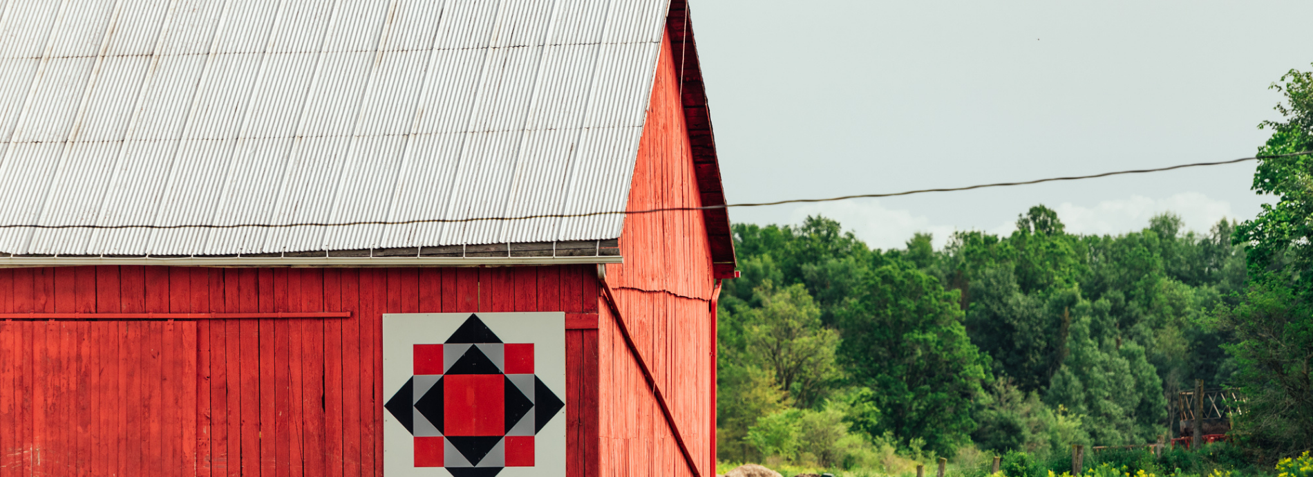 red barn in a rural area with a barn quilt