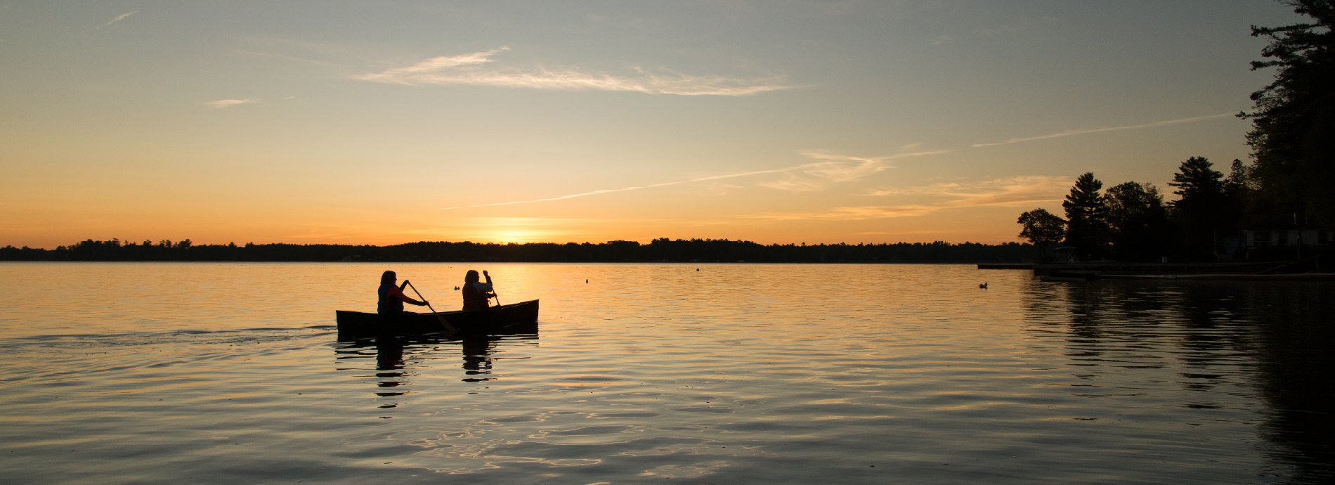 two people in a canoe at sunset